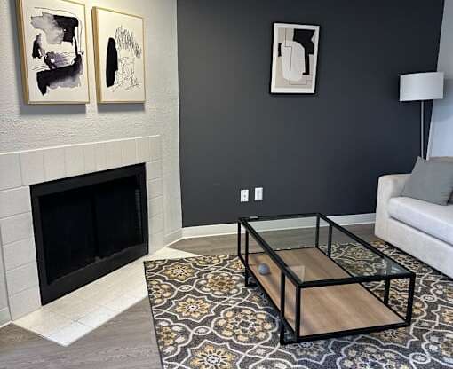 A living room with a fireplace and a coffee table.