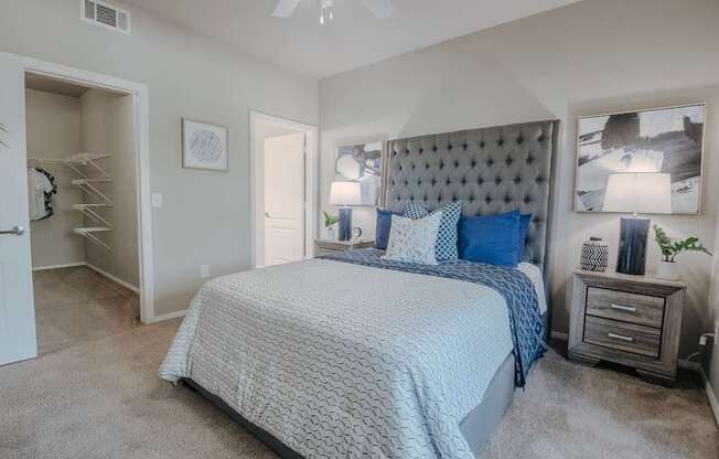 A bedroom with a bed, nightstand, and a ceiling fan.
