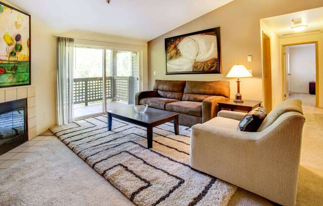 a living room with a couch and a chair and a fireplace