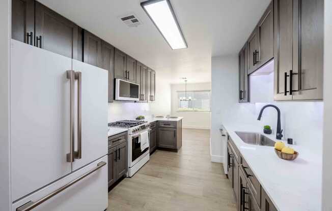 A modern kitchen with a white refrigerator and stainless steel appliances.