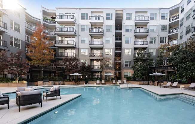 A large swimming pool in front of apartment buildings.