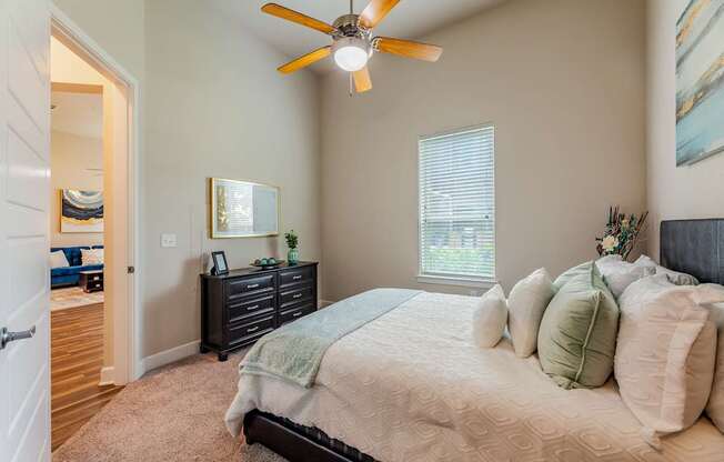 A bedroom with a bed, dresser, and mirror.