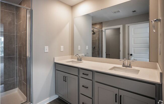 a bathroom with two sinks and a shower and a mirror