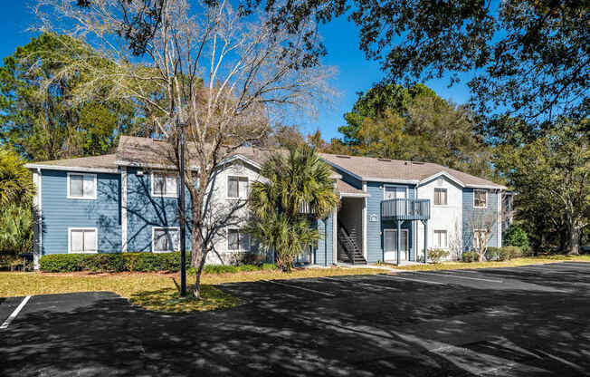 A blue building with a parking lot in front.