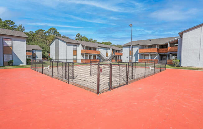 A fenced dog yard with apartment buildings in the background at The Marq in Shreveport, LA