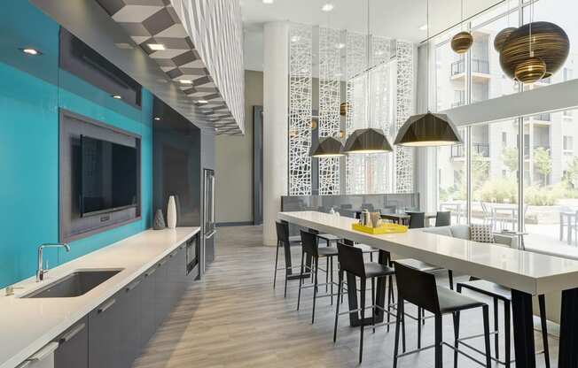 a kitchen with a long counter and a long table with chairs