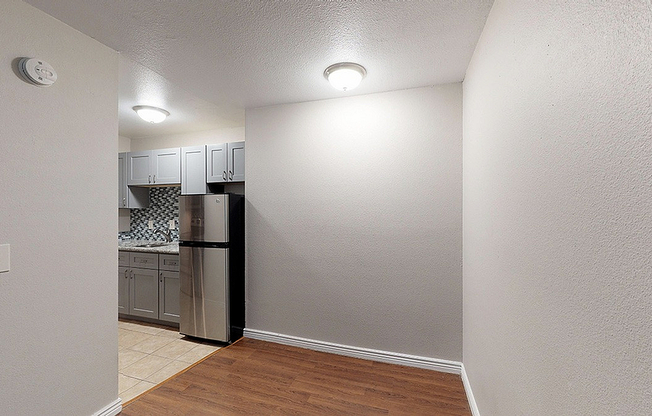 Chic apartment kitchen with modern cabinetry, stylish backsplash, and stainless steel appliances.
