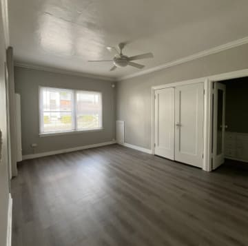 A room with a ceiling fan and a window.