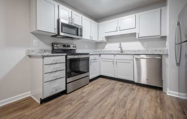 a kitchen with white cabinets and stainless steel appliances