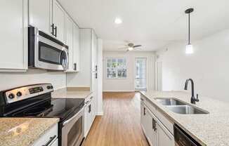 A kitchen with white cabinets and a granite countertop.