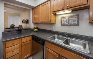 a kitchen with granite counter tops and wooden cabinets and a sink