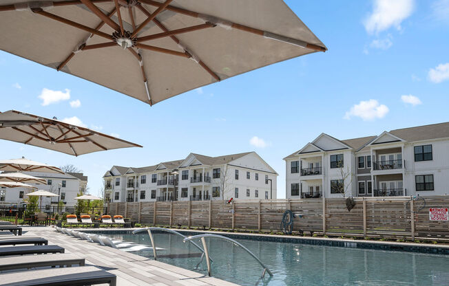 A pool area with sun umbrellas and apartment buildings in the background at Madison Prickett Preserve, Yardley Pennsylvania