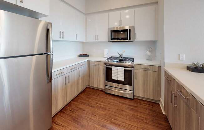 A modern kitchen with wooden cabinets and stainless steel appliances.