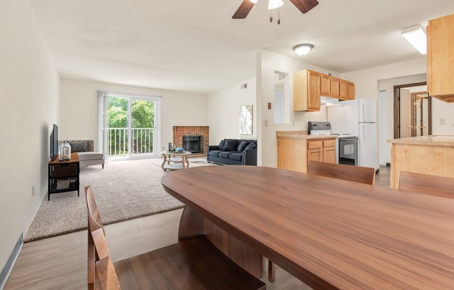 A modern kitchen with wooden cabinets and a dining table.