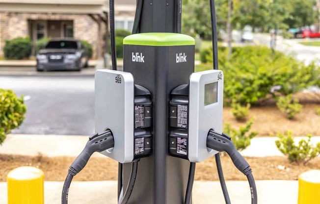 A Blink charging station for electric vehicles is shown with two charging ports.