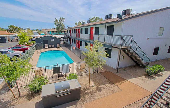 A pool surrounded by a fence and a building.
