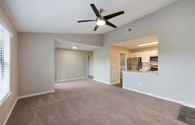 Model living room with ceiling fan and carpet at Fountains at Lee Vista in Orlando, Florida.