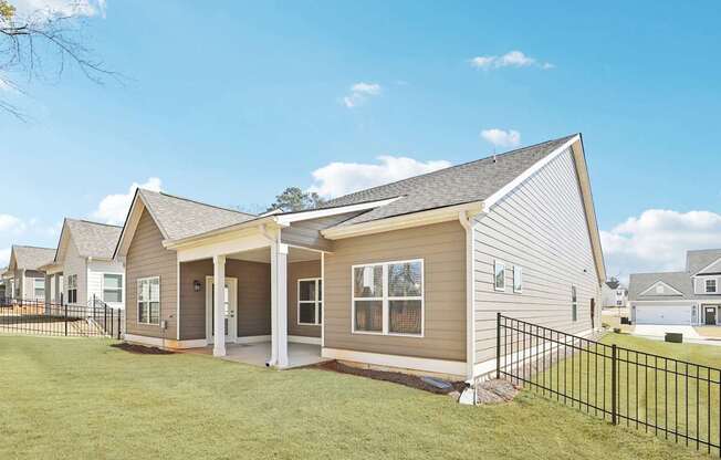 A house with a grey siding and a black fence.