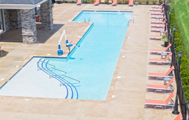 an aerial view of a swimming pool with chairs around it