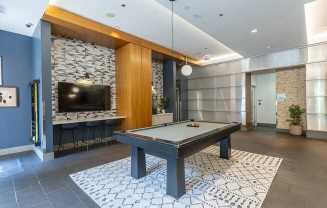 a spacious game room with a pool table and a flat screen tv