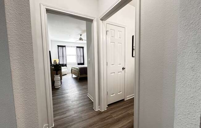 a view of the living room from the hallway with the bedroom door open