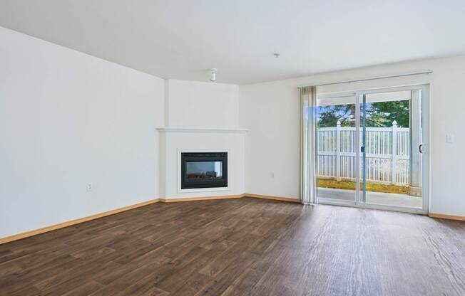 Spacious York living room with a fireplace and sliding glass doors at Abbey Rowe Apartments in Olympia, WA