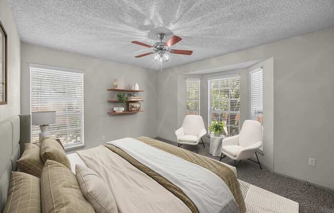 A bedroom with a large bed and a ceiling fan.