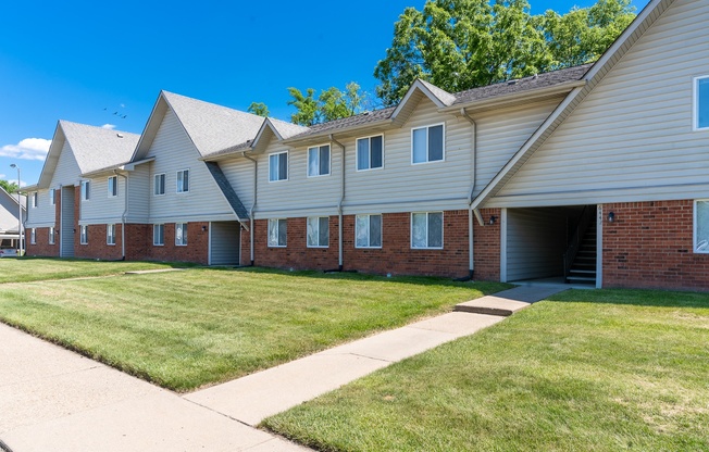 a row of houses with a sidewalk and grass