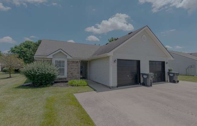 a white house with a driveway and a garage door