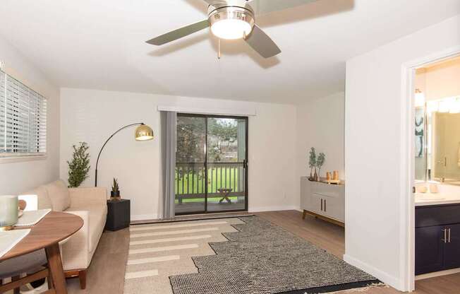 A living room with a sliding glass door leading to a backyard.