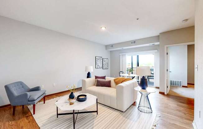 A living room with a white couch and a grey chair.
