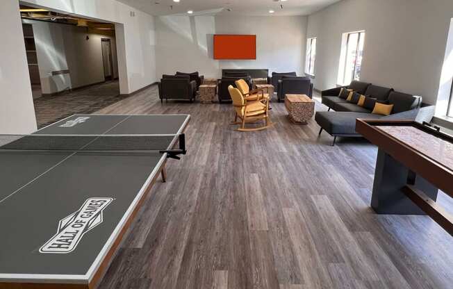 an open living room with a ping pong table and couches