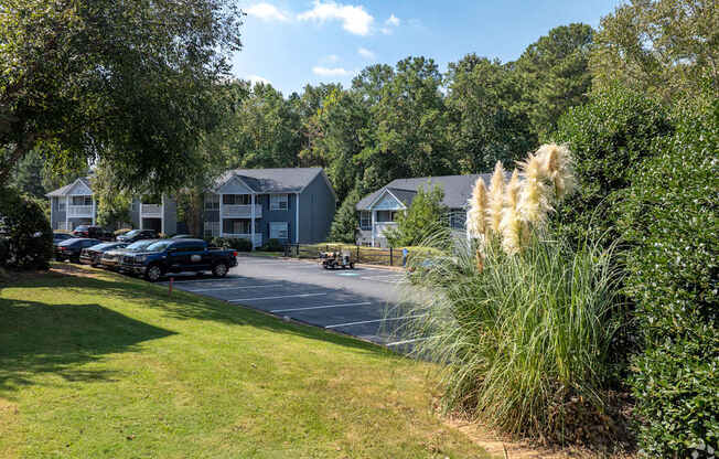 A row of houses with cars parked in front.