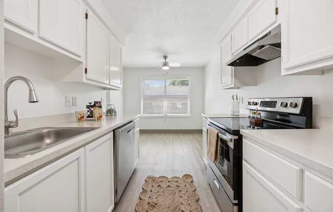 A kitchen with white cabinets and a black stove top oven.