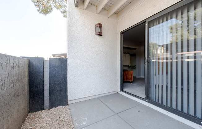 A patio area with a sliding glass door leading to a dining area.