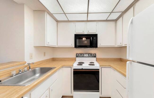 a kitchen with white cabinets and a stove and a sink