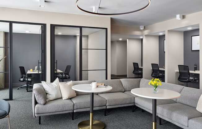A modern living room with grey couches and a white coffee table.
