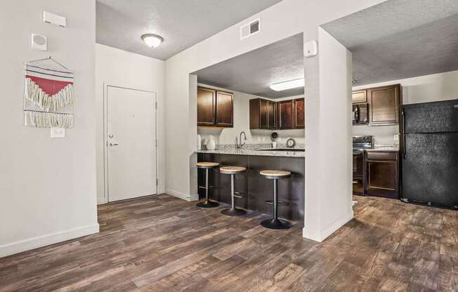 A kitchen with a bar stool and a counter.
