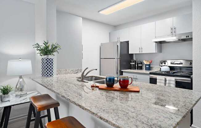 A kitchen with a marble countertop and a stool.