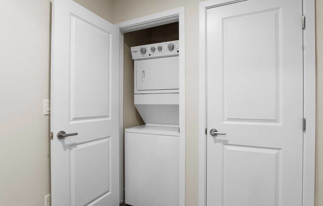a pantry with white doors and a white stove and dishwasher at The Flats at Riverwoods, Provo, UT, 84604