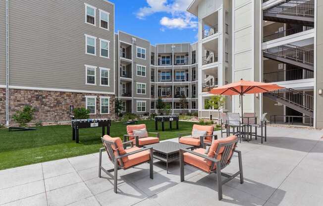 A patio with a table and chairs is in front of a building.