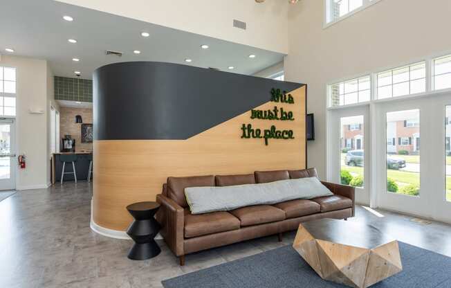 a living room with a couch and a wall with a sign