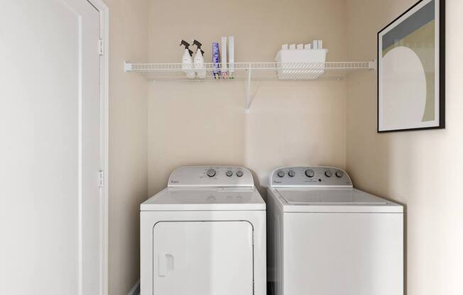 Two white front loading washing machines in a laundry room.