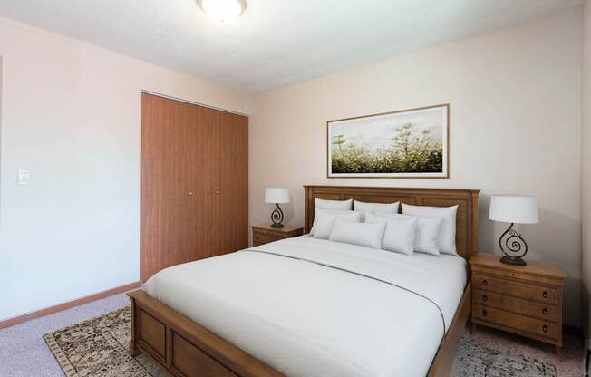A bedroom with a large bed, a wooden headboard, and a painting above the bed. Bismarck, ND Parkview Arms Apartments