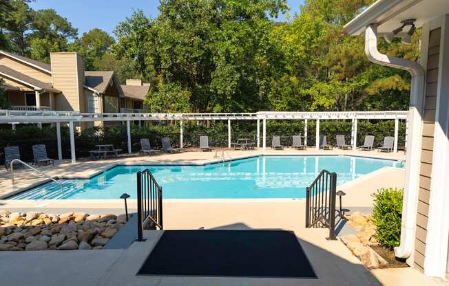 A pool surrounded by a white fence and a black mat.