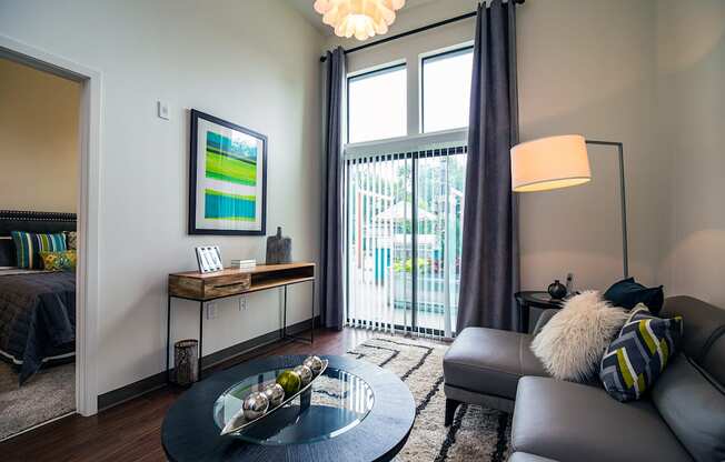 a living room with a large window and a sliding glass door at Link Apartments® Canvas, Georgia, 30312