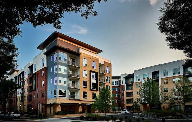 A modern apartment complex with a mix of red, blue, and beige buildings.