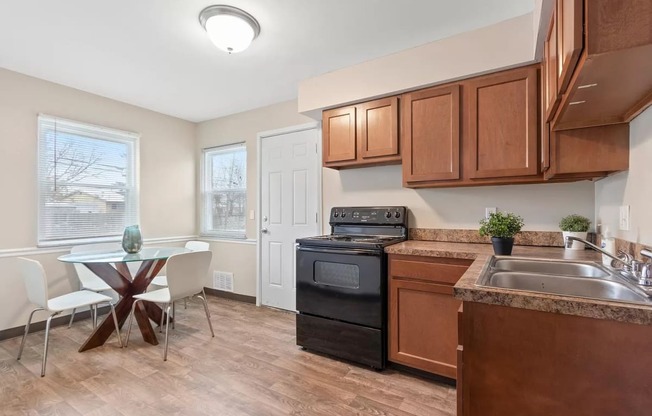 a kitchen with wooden cabinets and a table with chairs