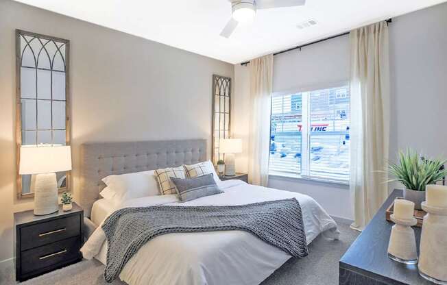 A bedroom with a large bed and a window overlooking a cityscape.