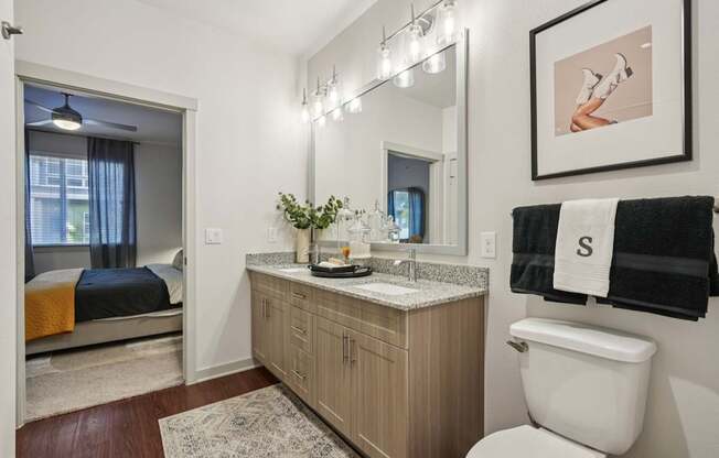 A bathroom with a toilet, sink, and bed.